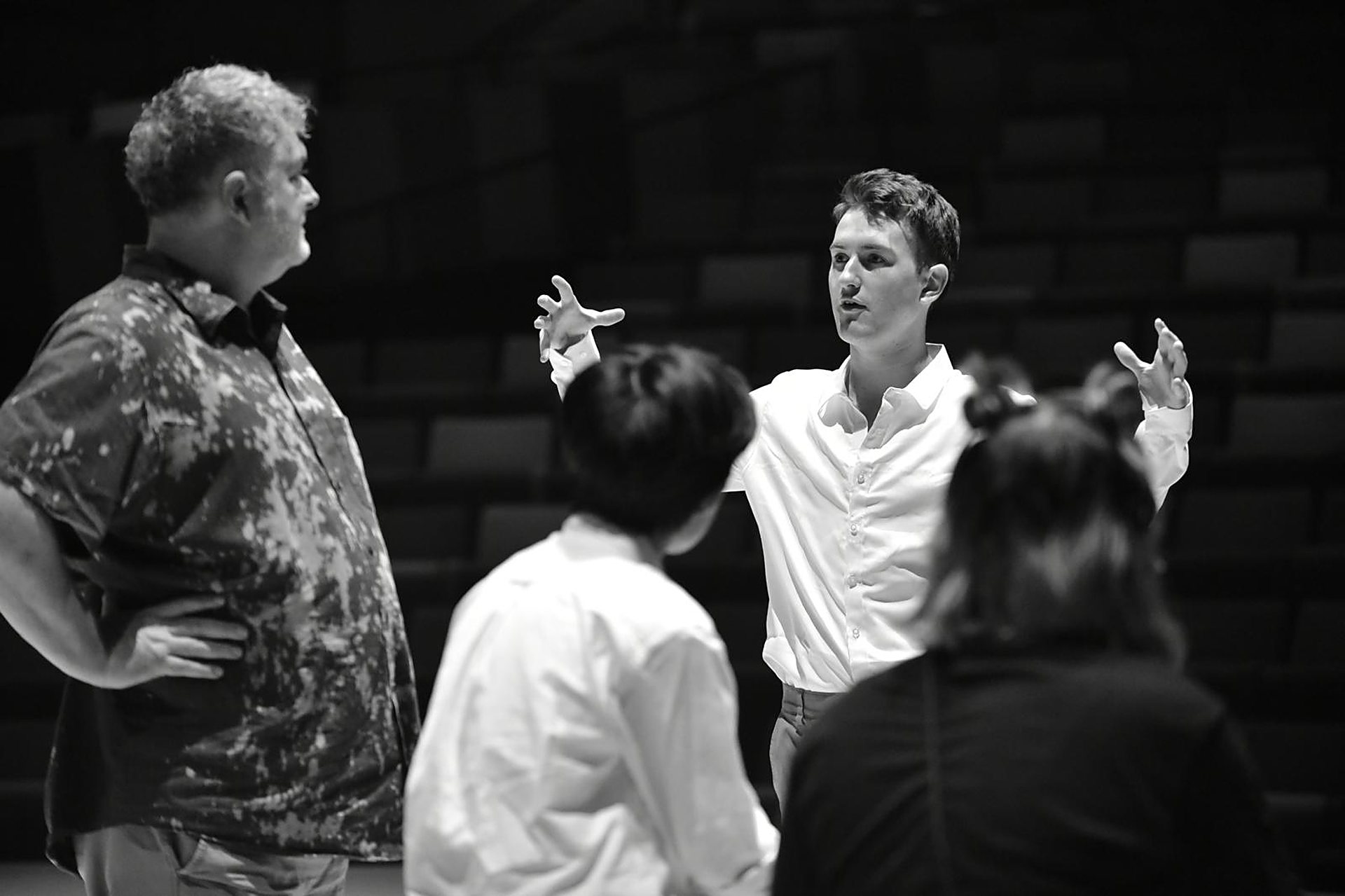 Andrei, in black and white, mid-gesture as he talks a group through a scene